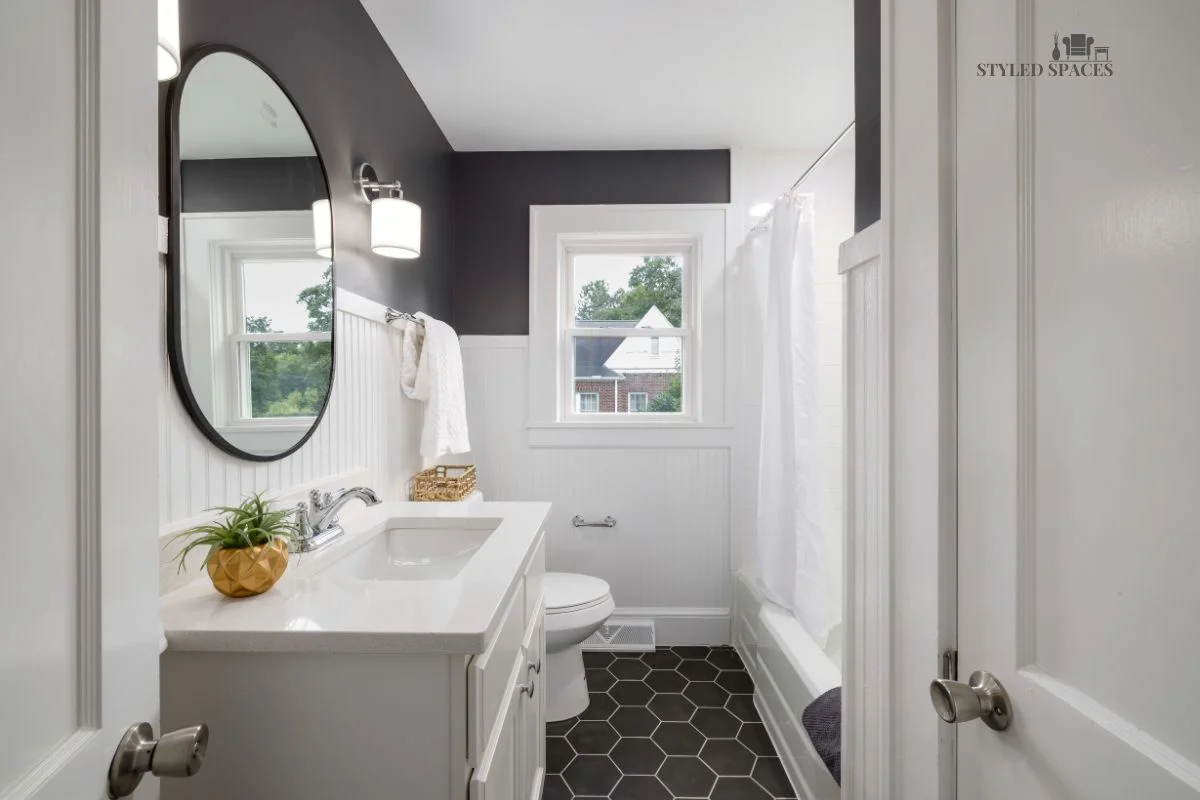 Tall bathroom ceiling visually anchored with a darker ceiling color and tile border