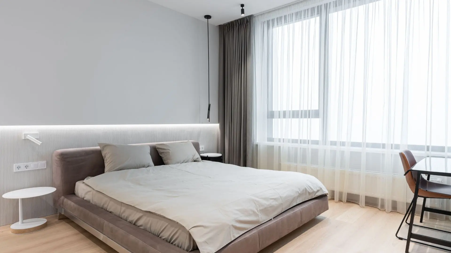 Calm, hotel-like bedroom with layered lighting and soft bedding