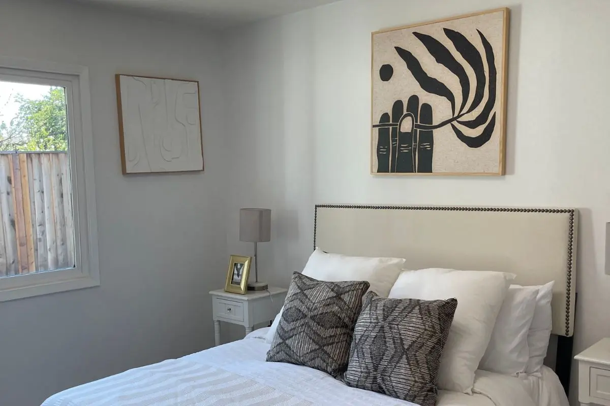 Large piece of art centered above a bed headboard