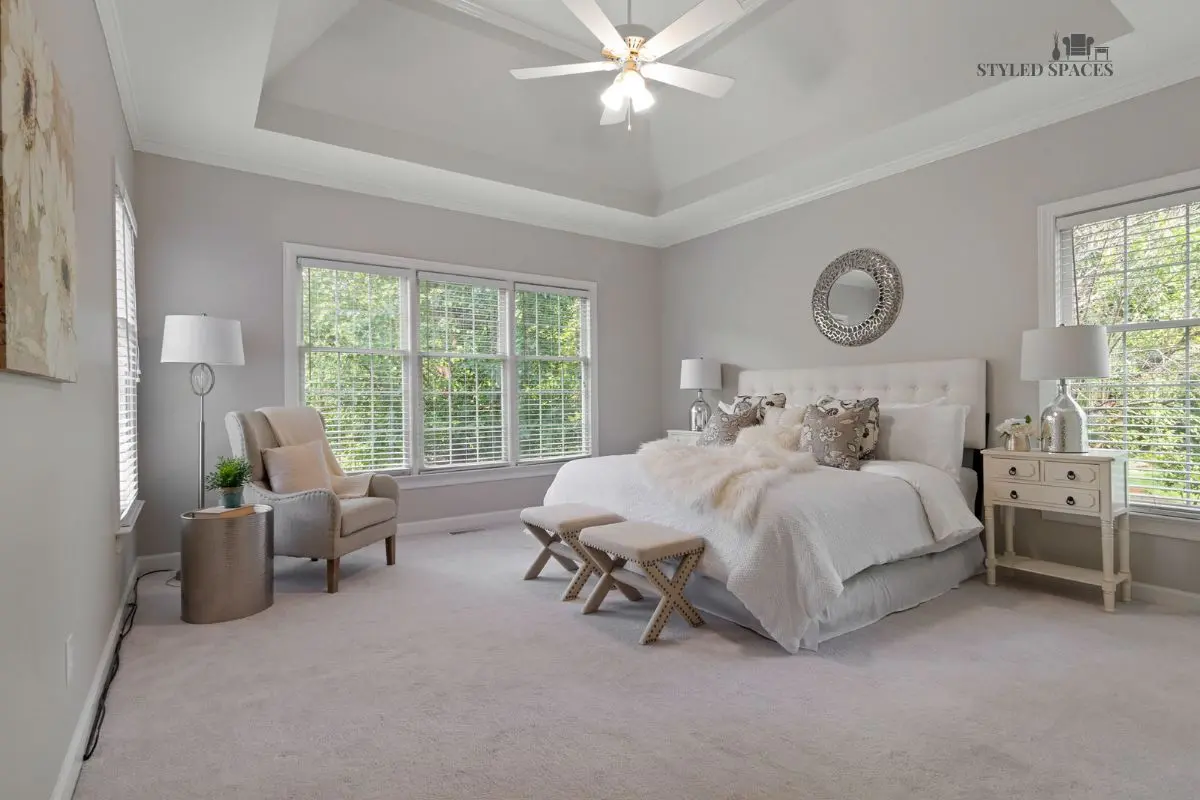 Tall bedroom ceiling anchored with a statement pendant and layered lighting