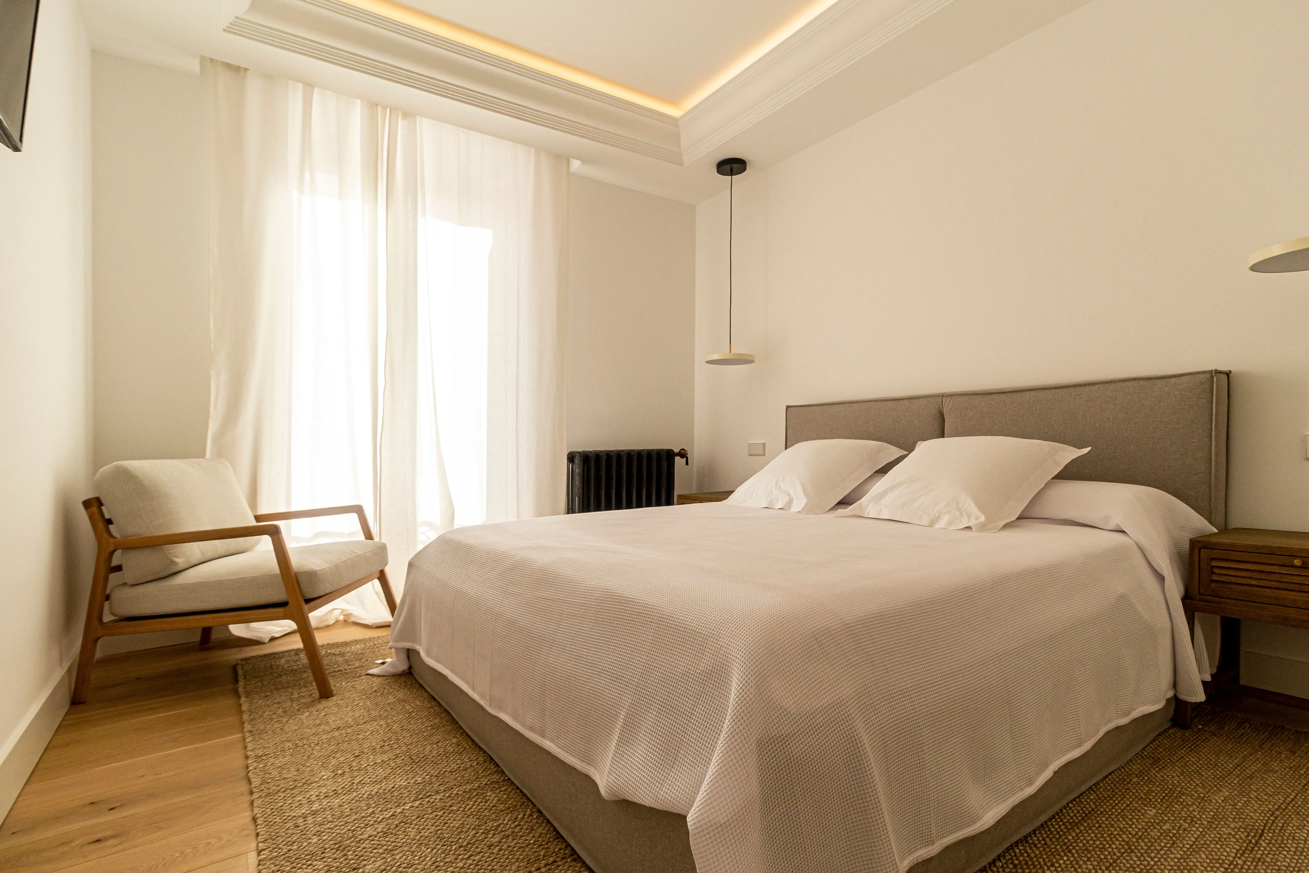 Comfortable lounge chair added to a bedroom corner for a lived-in feel