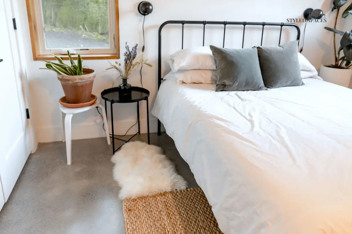 Metal bed frame warmed up with layered textures and a soft rug
