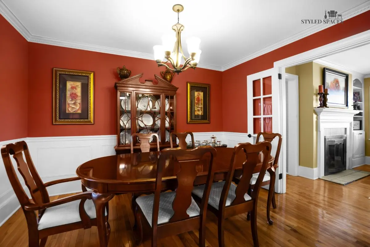 Dark stone dining room warmed up with rich color and a wrought-iron chandelier