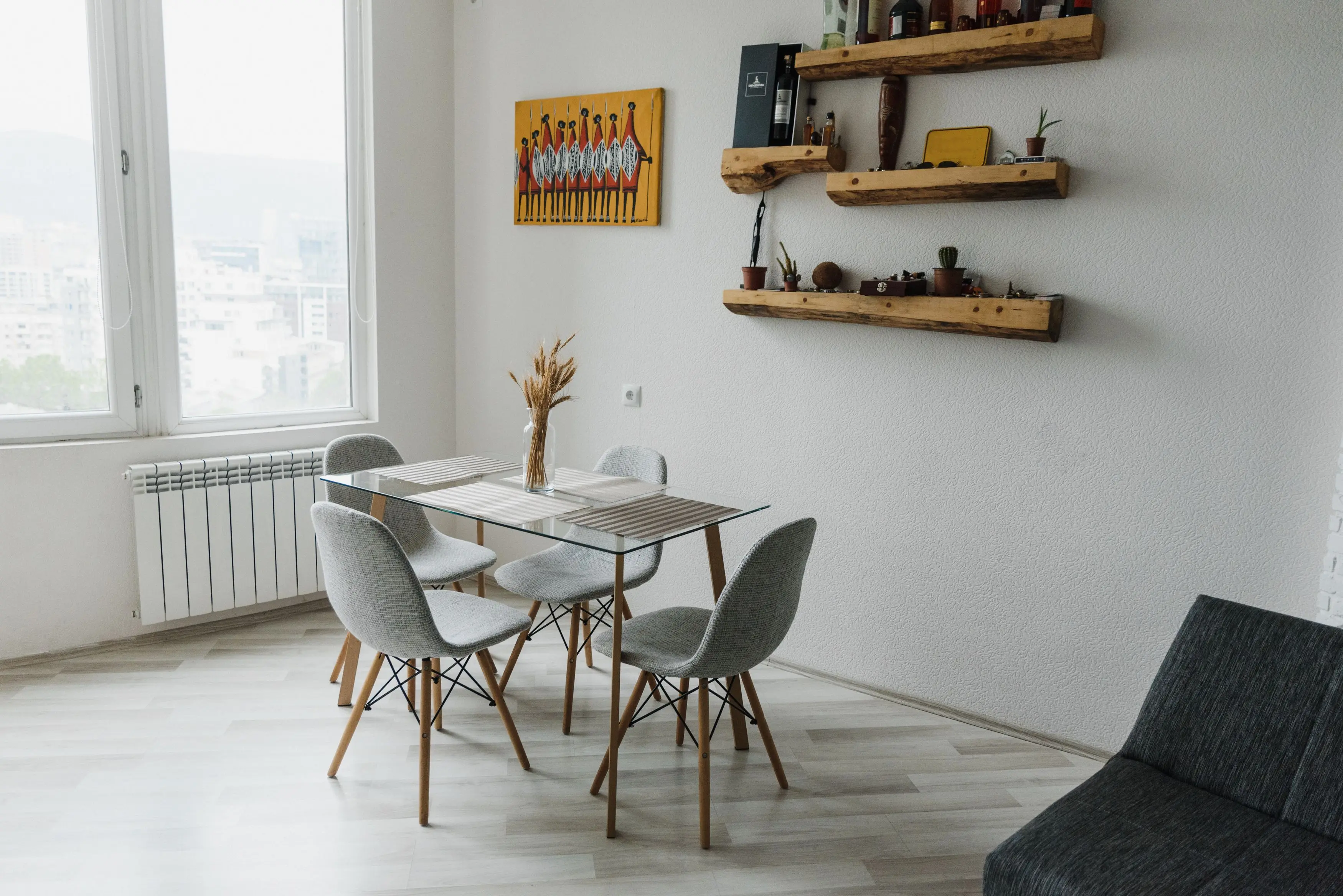 Small square dining room with a glass-top table that keeps the space feeling open
