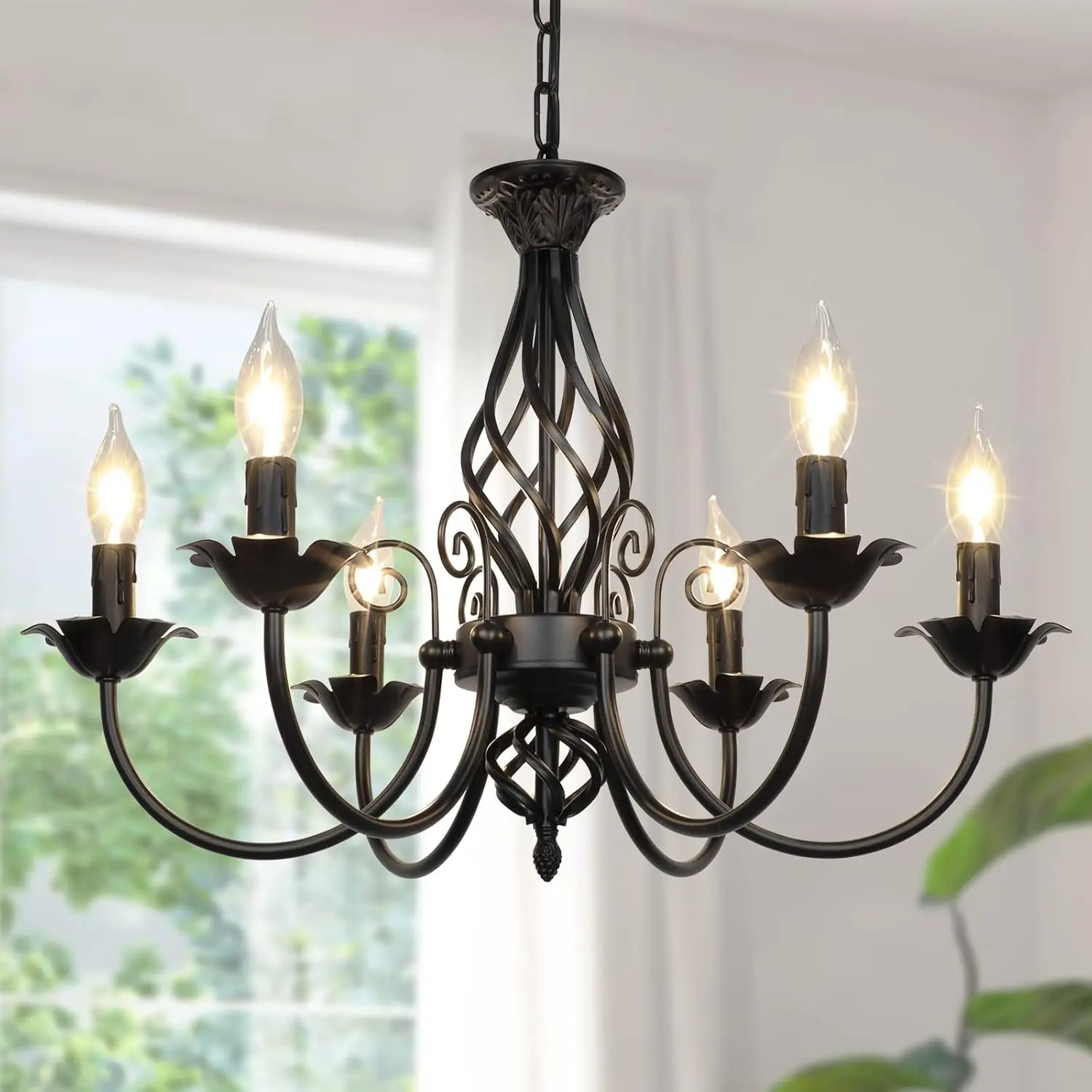 Six-arm matte black candle chandelier over a dining space