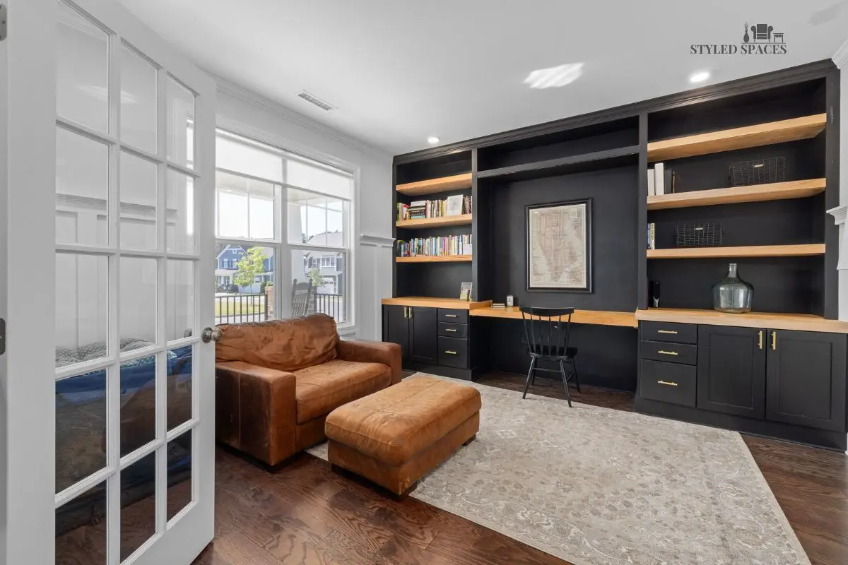 Floor-to-ceiling library bookshelves with a desk in the center of the room